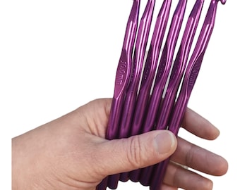 May include: Set of six purple crochet hooks, each measuring 10.0mm. The hooks are held in a hand.