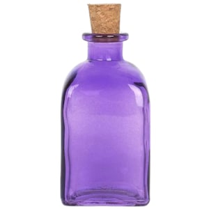 Puede incluir: Una pequeña botella de vidrio de forma cuadrada con un tapón de corcho. La botella es de color morado vibrante.