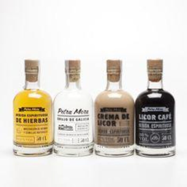 K&ouml;nnte beinhalten: Vier Glasflaschen mit Korken, jede mit einer unterschiedlich farbigen Fl&uuml;ssigkeit gef&uuml;llt. Die Flaschen sind mit spanischem Text beschriftet, darunter "DE HIERBAS" und "LICOR CAFE". Jede Flasche enth&auml;lt 50 ml.