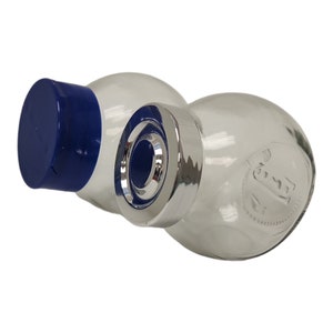 May include: Two clear glass salt and pepper shakers with blue and silver lids. The shakers are round and have a textured surface. The lids have a silver band around the top and a blue top.