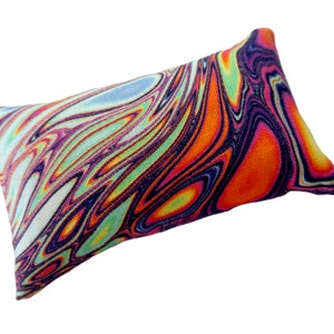 Puede incluir: Un cojín decorativo rectangular con un vibrante patrón arremolinado en tonos naranja, morado, azul y verde. El cojín tiene un fondo blanco y una apariencia suave y texturizada, adecuado para la decoración del hogar.