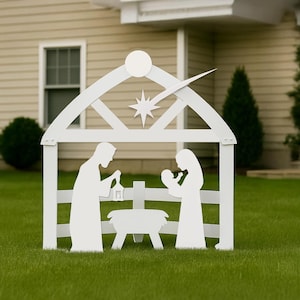 May include: A white, outdoor nativity scene silhouette. The scene depicts the holy family in a stable, with a star and comet above. The figures are set on a green lawn in front of a house.