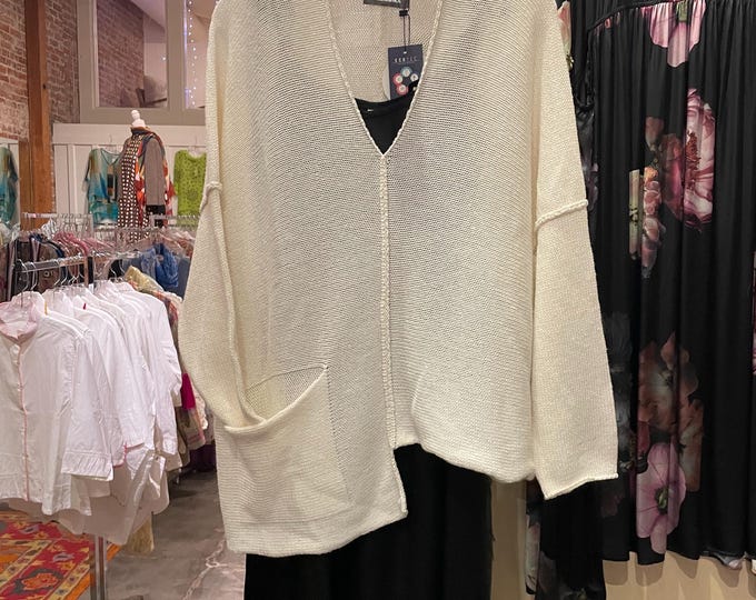 One size  cream color asymmetrical sweater with one pocket