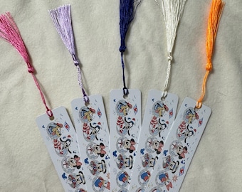 May include: Five white metal bookmarks with colorful tassels. Each bookmark features a cartoon design with Mickey Mouse, Minnie Mouse, and Pluto in nautical outfits. Tassels are pink, purple, blue, white, and orange.