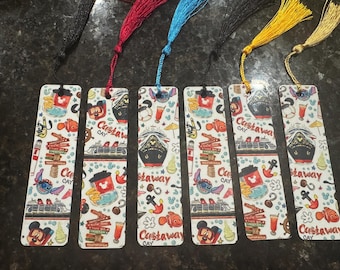May include: Six rectangular bookmarks with colorful illustrations and tassels. Each bookmark features a cruise ship, Mickey Mouse, Stitch, and the words "Castaway Cay". The tassels are black, red, blue, yellow, and gold.