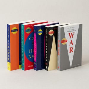 May include: A collection of five books by Robert Greene standing upright. The titles include The Concise 48 Laws of Power, The Concise Laws of Human Nature, The Art of Seduction, The Concise Mastery, and The Concise 33 Strategies of War, each featuring a distinct color scheme and an International Bestseller seal.