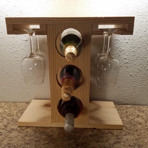 May include: A handmade, wooden serving tray with a natural finish. The tray features a rectangular shape with raised edges and two handles. The wood grain is visible, adding to its rustic charm. Perfect for serving food or displaying items.