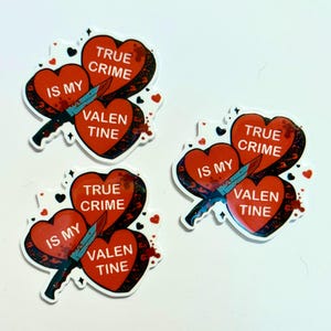 May include: Three heart-shaped stickers with the text "True Crime Is My Valentine." Each sticker features a blue knife piercing two red hearts, with blood splatter details and small heart accents.