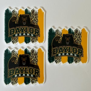 May include: Three rectangular stickers featuring the Baylor Bears logo. The logo includes a brown bear, the word "BAYLOR" in gold, and the word "BEARS" in white. The background has green and gold stripes with a leopard print.