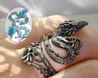 May include: A detailed, antique-style dragon ring in a bronze finish. The ring wraps around the finger, featuring a dragon's head and body. An inset image shows a dragon with blue accents. A unique piece of jewelry.