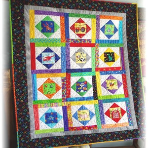 Pode incluir: Uma colcha colorida com um design de patchwork que apresenta várias aplicações de animais e veículos. A colcha é enquadrada com uma borda preta com estrelas brancas.