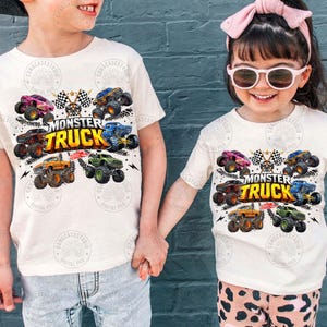 Puede incluir: Dos ni&ntilde;os con camisetas blancas con un gr&aacute;fico de monster truck colorido. El dise&ntilde;o presenta varios monster trucks, banderas a cuadros y las palabras "MONSTER TRUCK". Los ni&ntilde;os se dan la mano.