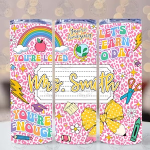 Peut inclure: Un gobelet rose avec un motif l&eacute;opard, orn&eacute; d'un arc-en-ciel, d'une pomme et des mots "You're Loved", "You're Amazing", "Let's Learn Today" et "You're Enough". Le gobelet est personnalis&eacute; avec le nom "Mrs. Smith".