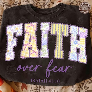 May include: Black sweatshirt with the words "FAITH over fear" in a floral and striped design. The word "FAITH" is in large, decorative letters with a purple lace trim. The text "ISAIAH 41:10" is below.