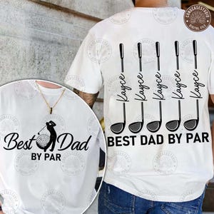 Może przedstawiać: Biały t-shirt z czarnymi grafikami. Z tyłu znajduje się pięć ilustracji kijów golfowych z imieniem Kayce napisanym pionowo wzdłuż każdego trzonka, nad napisem BEST DAD BY PAR. Z przodu widoczny jest golfista, piłeczka oraz napis Best Dad BY PAR.