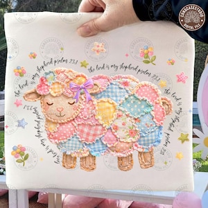 May include: A decorative pillow featuring a patchwork sheep design in pastel colors. The sheep has a purple bow and is surrounded by floral and star accents. The text "the lord is my shepherd psalm 23:1" is written around the sheep.