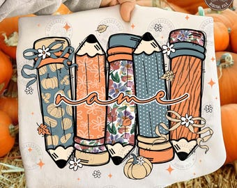 May include: A cream-coloured pencil-themed design featuring five pencils with autumn-themed patterns and a cursive "name" in the centre. The pencils have pumpkin, floral, and dotted patterns, with ribbons and flowers.