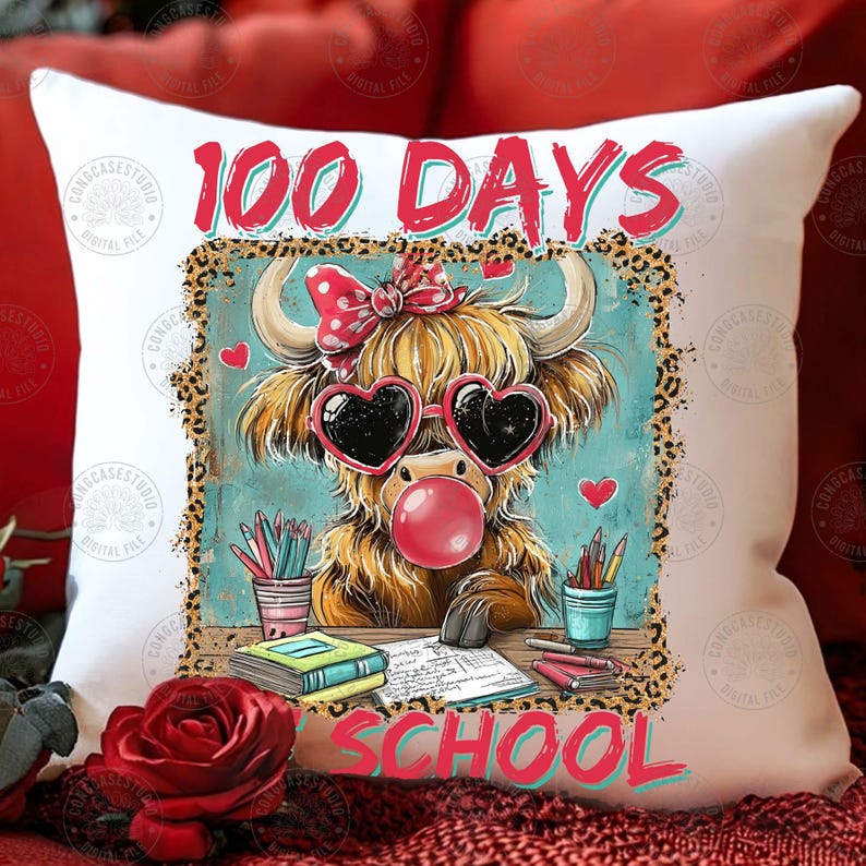 May include: White cushion featuring a cartoon Highland cow with heart-shaped sunglasses and a bubble. The text "100 DAYS SCHOOL" is displayed in red and teal. The design includes pencils and books.