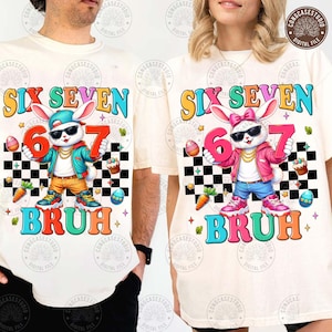 Pode incluir: Duas camisetas creme com um design gráfico colorido. O design apresenta um coelho usando óculos de sol e segurando os números 6 e 7. A palavra "BRUH" está abaixo do coelho. Elementos temáticos da Páscoa, como ovos e cenouras, também estão incluídos.