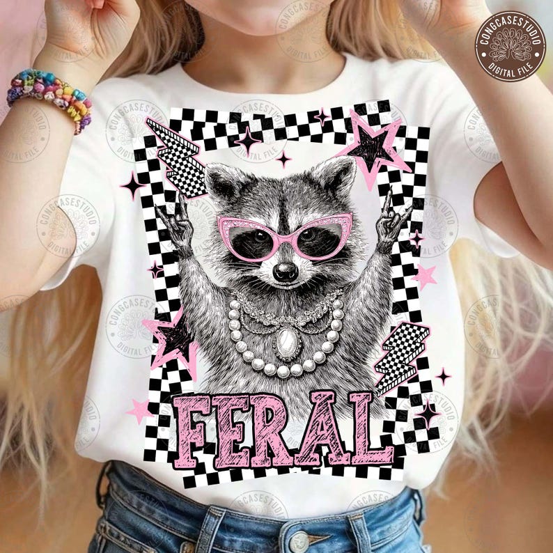 May include: White t-shirt featuring a raccoon wearing pink sunglasses and a pearl necklace. The raccoon is surrounded by pink stars, black and white checkered patterns, and the word "FERAL" in pink letters.