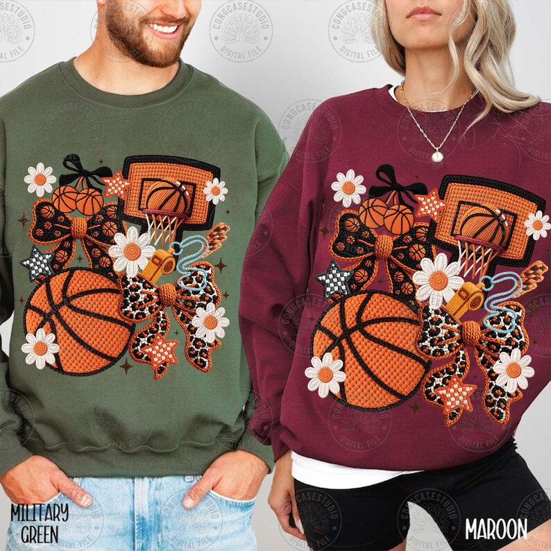 May include: Two sweatshirts, one military green and one maroon, each with a basketball-themed design. The design includes a basketball, hoop, bow, flowers, and stars. The military green sweatshirt has the text "MILITARY GREEN" at the bottom.
