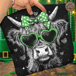 May include: Black pillow featuring a Highland cow illustration with heart-shaped sunglasses and a bow. The cow is white and black, with green accents. The pillow has a digital file logo in the corner.