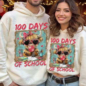 May include: Cream-coloured hoodies with a graphic of a Highland cow wearing heart-shaped sunglasses and blowing a bubblegum bubble. The text "100 DAYS OF SCHOOL" is above and below the graphic. The design is framed with a leopard print border.