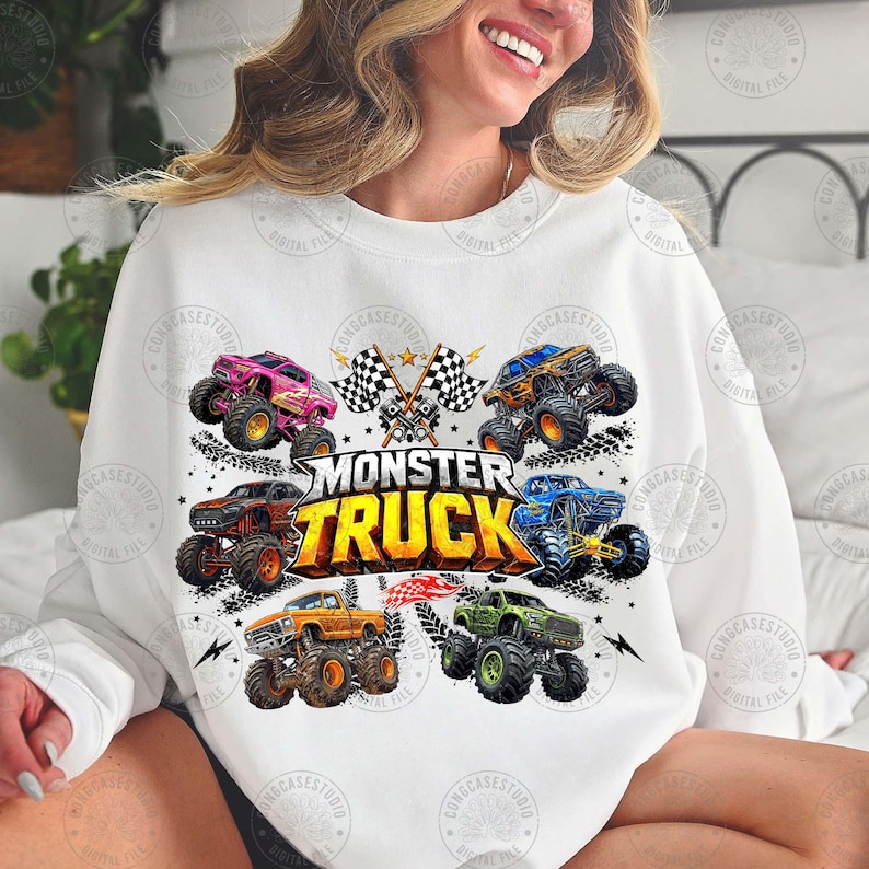 Puede incluir: Sudadera blanca con un gr&aacute;fico colorido de monster trucks. El dise&ntilde;o incluye varios monster trucks de diferentes colores, banderas a cuadros y el texto "MONSTER TRUCK".