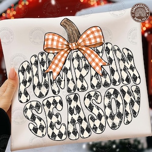 May include: A white graphic design featuring the text PUMPKIN SEASON in a black and white diamond pattern. A brown pumpkin stem sits atop the text, adorned with a large orange and white gingham bow. The design has a distressed texture.