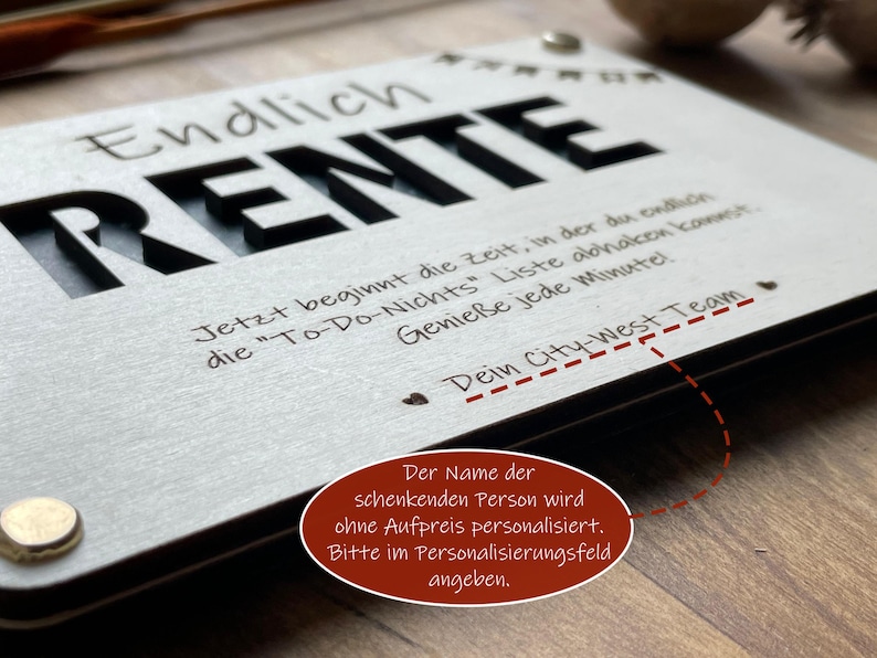 May include: A white wooden sign with black lettering that reads "Endlich Rente" and a message about enjoying retirement. The sign is personalized with the text "Dein City-West Team".