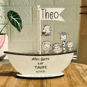 May include: Wooden sailboat shaped sign with the name Theo, animals, and the text "Alles Gute zur Taufe 16.09.1014 Oma & Opa".