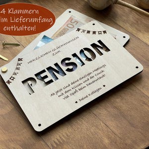 May include: A wooden card with a cut-out design that says "Pension" and a message that reads "Ab jetzt sind deine einzigen Meetings mit dem Kissen und der Couch. Viel Spa&szlig; beim Dauerurlaub! Deine Kollegen".