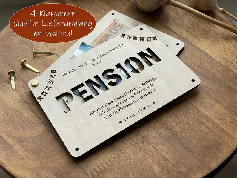 May include: A wooden card with a cut-out design that says "Pension" and a message that reads "Ab jetzt sind deine einzigen Meetings mit dem Kissen und der Couch. Viel Spa&szlig; beim Dauerurlaub! Deine Kollegen".