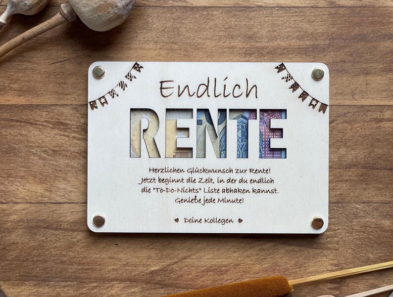 May include: A wooden sign with the word "RENTE" cut out, revealing a glimpse of money behind it. The sign reads "Endlich RENTE" and includes a message congratulating someone on their retirement, wishing them well and encouraging them to enjoy their time off. The sign is decorated with small flags.