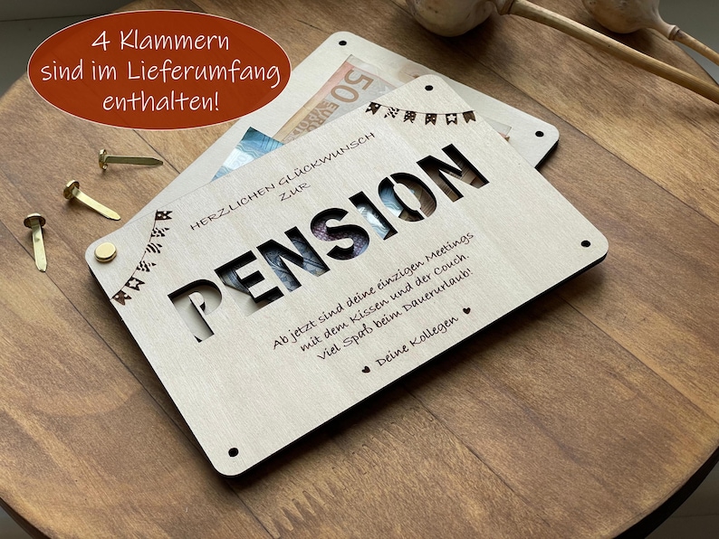May include: A wooden card with a cut-out design that says "Pension" and a message that reads "Ab jetzt sind deine einzigen Meetings mit dem Kissen und der Couch. Viel Spa&szlig; beim Dauerurlaub! Deine Kollegen".