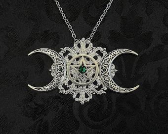 May include: Silver pendant necklace with a triple moon design and a green pentagram in the center.