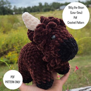 May include: A plush, brown bison with a cream-colored horn and black accents. The crochet animal has a textured, fuzzy appearance. Text on the image reads "Billy the Bison (Low-Sew) Pdf Crochet Pattern" and "PDF Pattern Only."