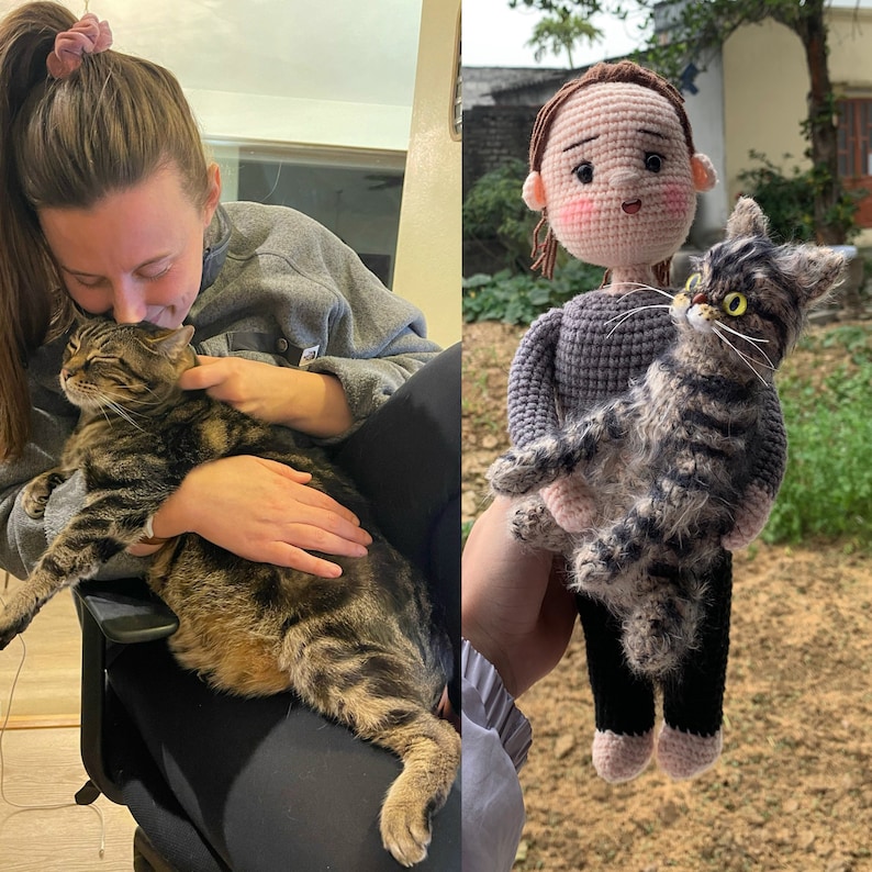 Puede incluir: Una mu&ntilde;eca de crochet con cabello casta&ntilde;o y un su&eacute;ter gris sostiene un gato de crochet con pelaje marr&oacute;n y blanco. La mu&ntilde;eca lleva zapatos rosas y el gato tiene ojos amarillos.