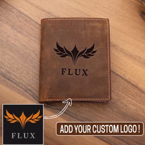 May include: A brown leather wallet with a black logo that says "FLUX" and a stylized wing design. The text "ADD YOUR CUSTOM LOGO!" is displayed below the wallet.