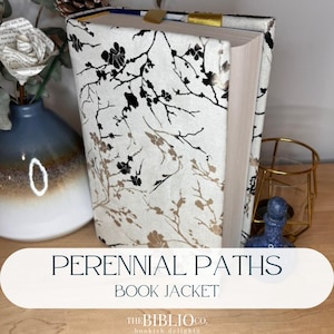 Peut inclure: Une jaquette de livre avec un fond crème et un motif floral noir et or. Le texte "PERENNIAL PATHS BOOK JACKET" est affiché en bas. Le logo The Biblio Co. est également visible.