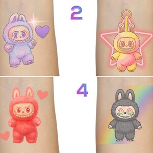 Puede incluir: Cuatro dise&ntilde;os de tatuajes temporales con personajes de dibujos animados con trajes de conejito. Los dise&ntilde;os incluyen un conejito morado con un coraz&oacute;n, un conejito amarillo con una estrella, un conejito rojo con corazones y un conejito gris con un fondo de arco&iacute;ris.