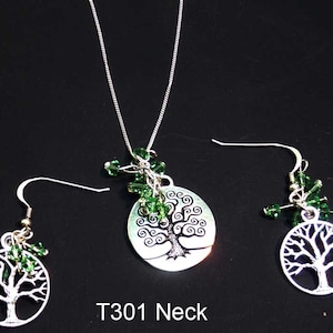 May include: A silver-coloured jewellery set with a tree of life design. The set includes a necklace and a pair of earrings. The necklace has a pendant with a detailed tree design, and the earrings have a similar tree motif. Green beads accent the pieces. Text on the image reads "T301 Neck".