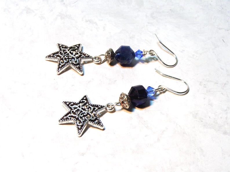 Image is of a pair of earrings with Star of David vintage charms. The dangling gemstones are bicone crystals, sodalite half rounds and a silvertone spacer.