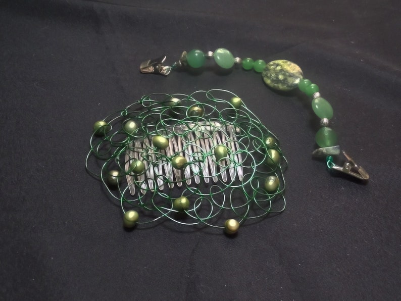 May include: A green wire hair comb with faux pearls and a matching beaded hair clip. The comb features a silver comb base with green wire and faux pearls. The beaded clip has green beads and silver accents.