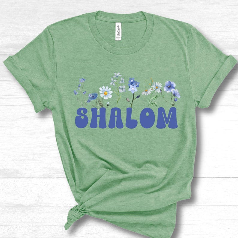 Image if of a mint prism color women's tee shirt with an image of floral wildflowers and the word Shalom T-Shirt designed by Linda or LinorStore