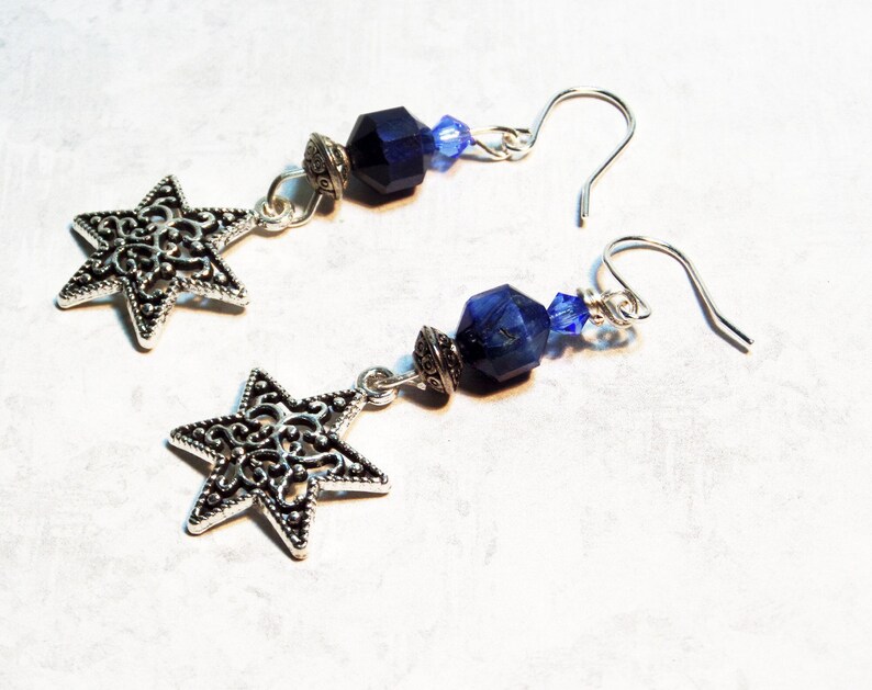 Image is of a pair of Star of David vintage charm earrings. The dangling gemstones are bicone crystals, sodalite half rounds and a silvertone spacer.