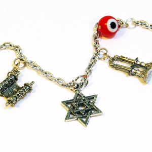 Photo of silver Jewish charm bracelet including hamsa, torah, star of david, shabbat charm & toggle clasp