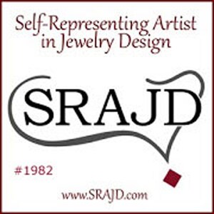 May include: A square logo with a white background features the text "Self-Representing Artist in Jewelry Design" in burgundy. Below, the letters "SRAJ D" are in black, encircled by a gray line. The number "#1982" and the website address "www.SRAJD.com" are also present.