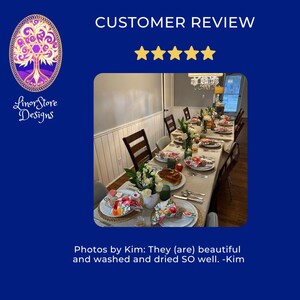 Puede incluir: Una mesa de comedor preparada para una comida, con servilletas, platos y manteles individuales con motivos florales. La mesa est&aacute; adornada con cubiertos, vasos y centros de mesa de flores blancas. Se incluye el texto "CUSTOMER REVIEW" y "Linor Store Designs".