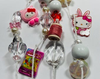 Diario de basura hecho a mano con cuentas colgantes decoradas con lomo de libro.